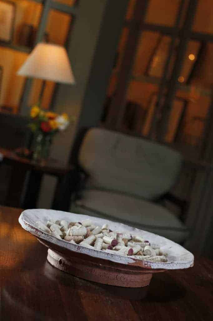 a large dish filled with wine bottle corks sits on top of a coffee table