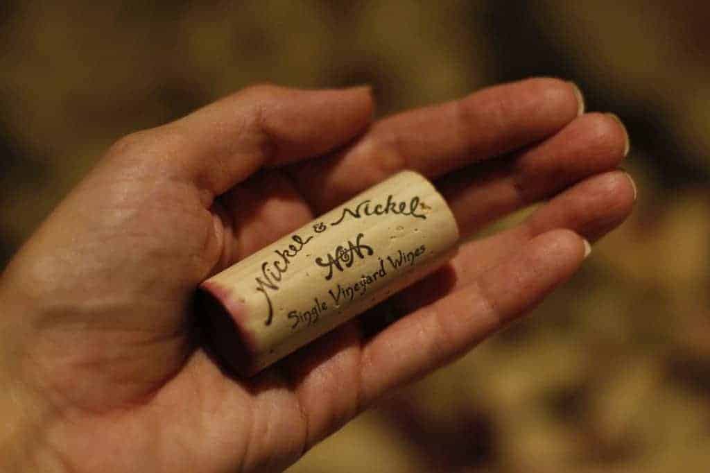a woman's hand holding a wine cork that says Nickel and Nickel 