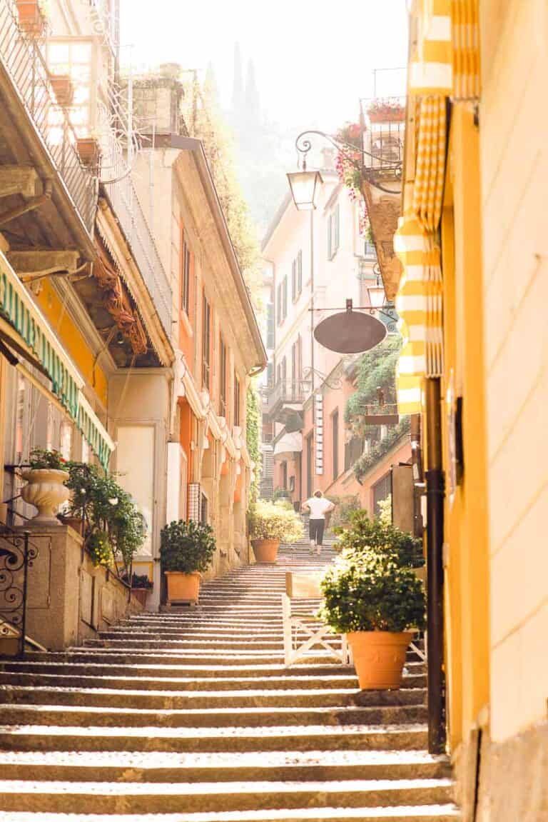 Sunrise on Old Picturesque Street in Bellagio City. Lombardy. Italy. Early Morning without Tourists. Woman Go Up on Staircase.