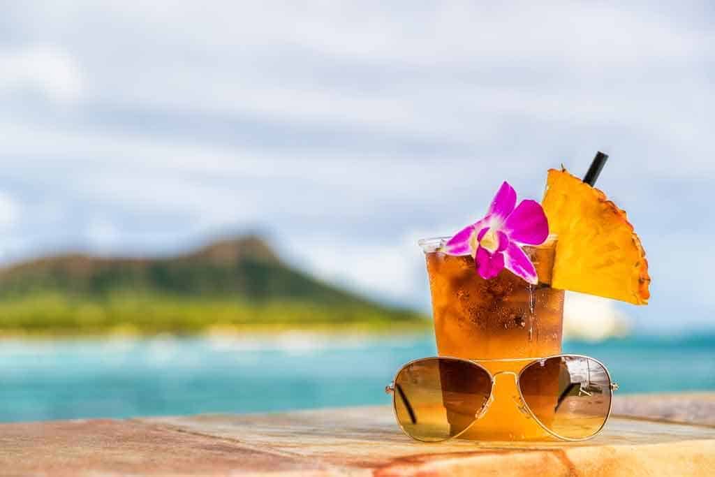 sunglasses in front of a tropical drink in hawaii