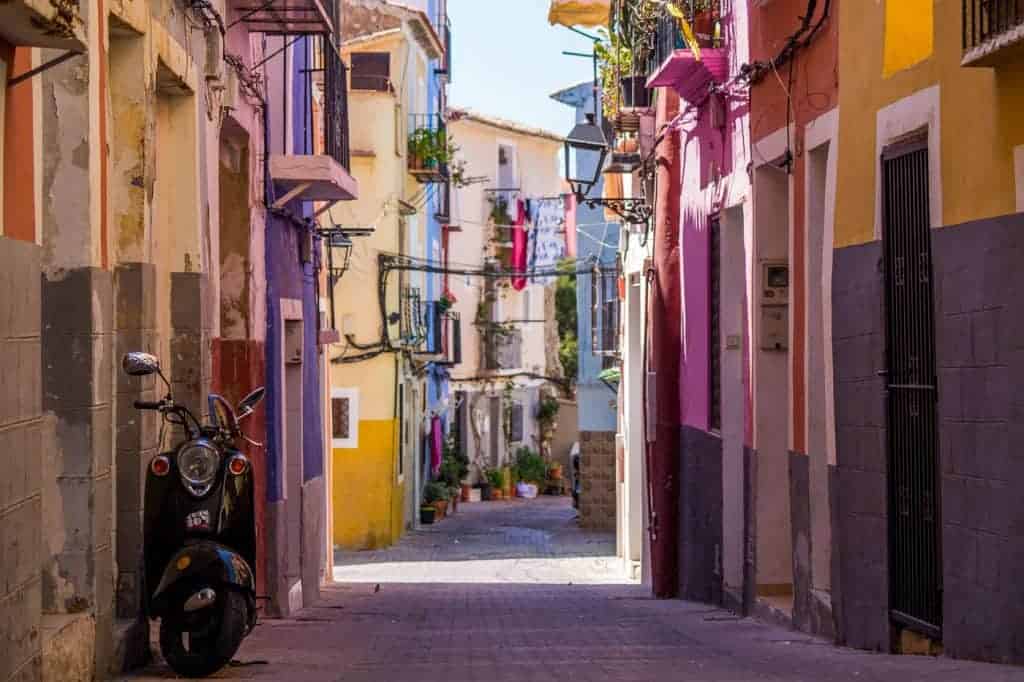 colorful shops line both sides of the street in spain