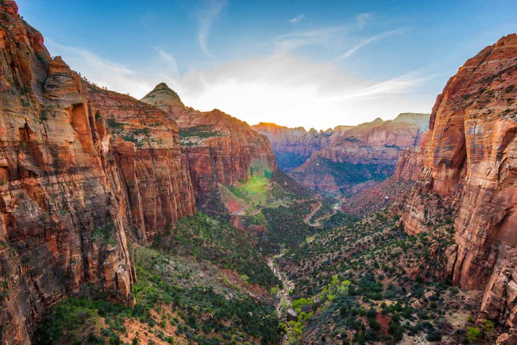 green canyon floor between red sandstone cliffs