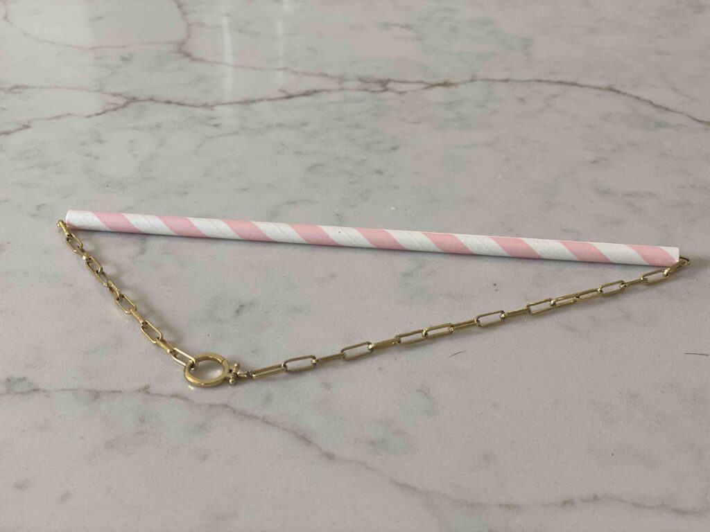 necklace threaded through a paper straw