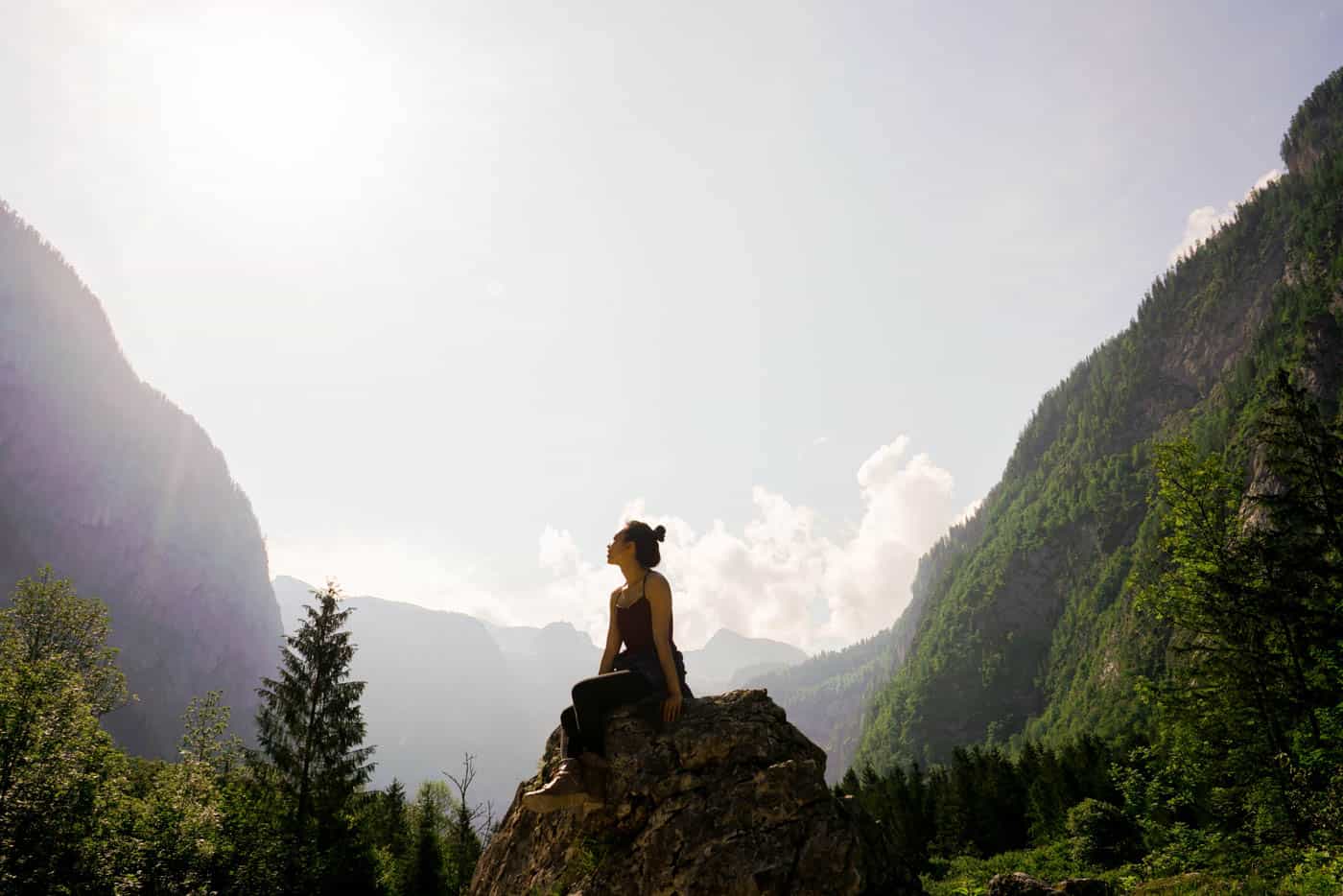 woman on top of a large rock in the forest