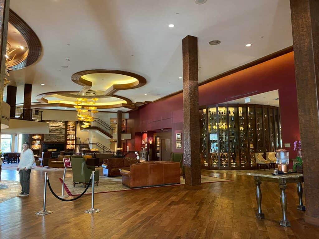 A large hotel lobby with dark wooden floors and a rustic, mountain feel