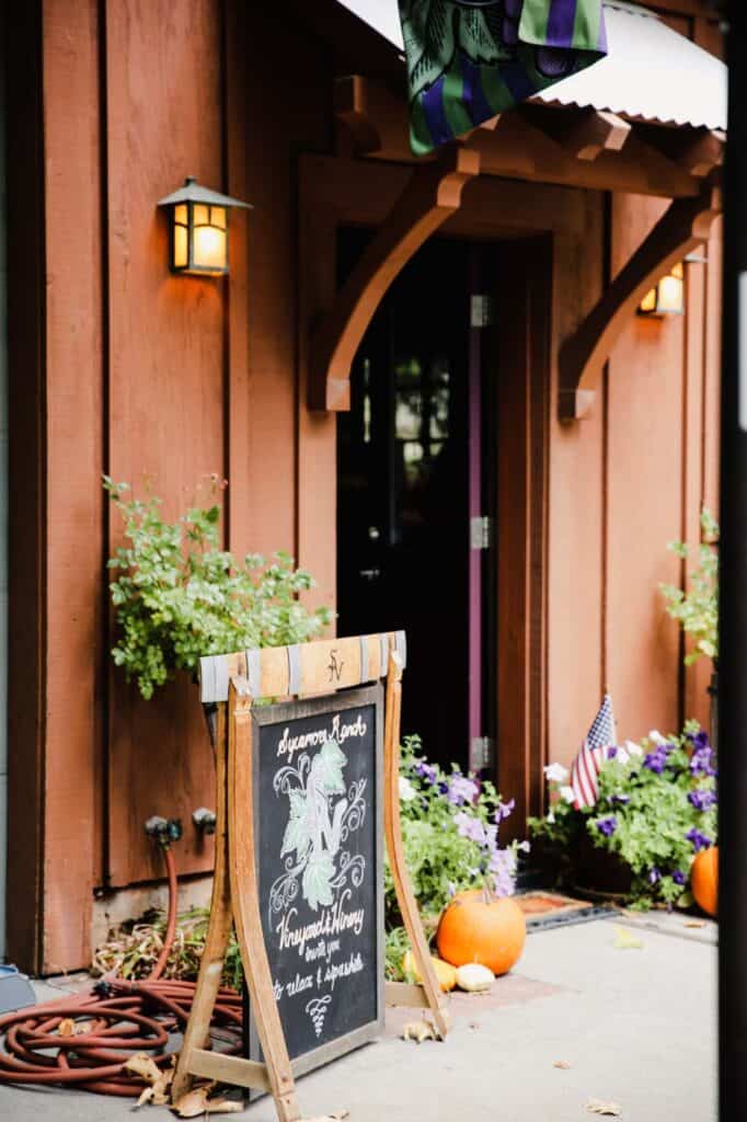 rustic doorway with fall decor and a sign welcoming visitors to sycamore ranch