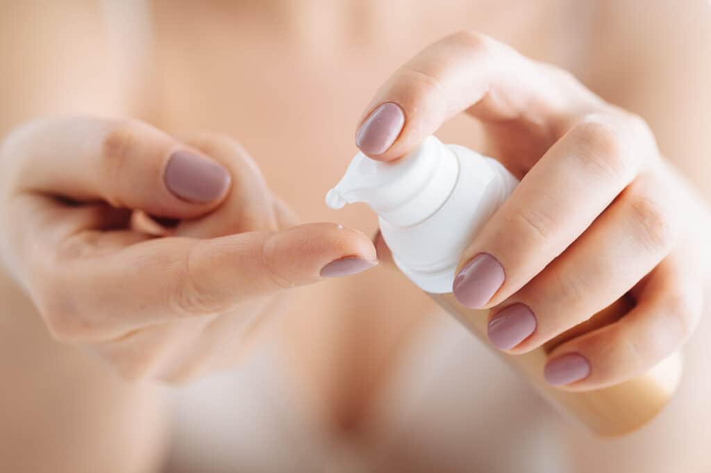 woman hands applying moisturizing cream to her skin