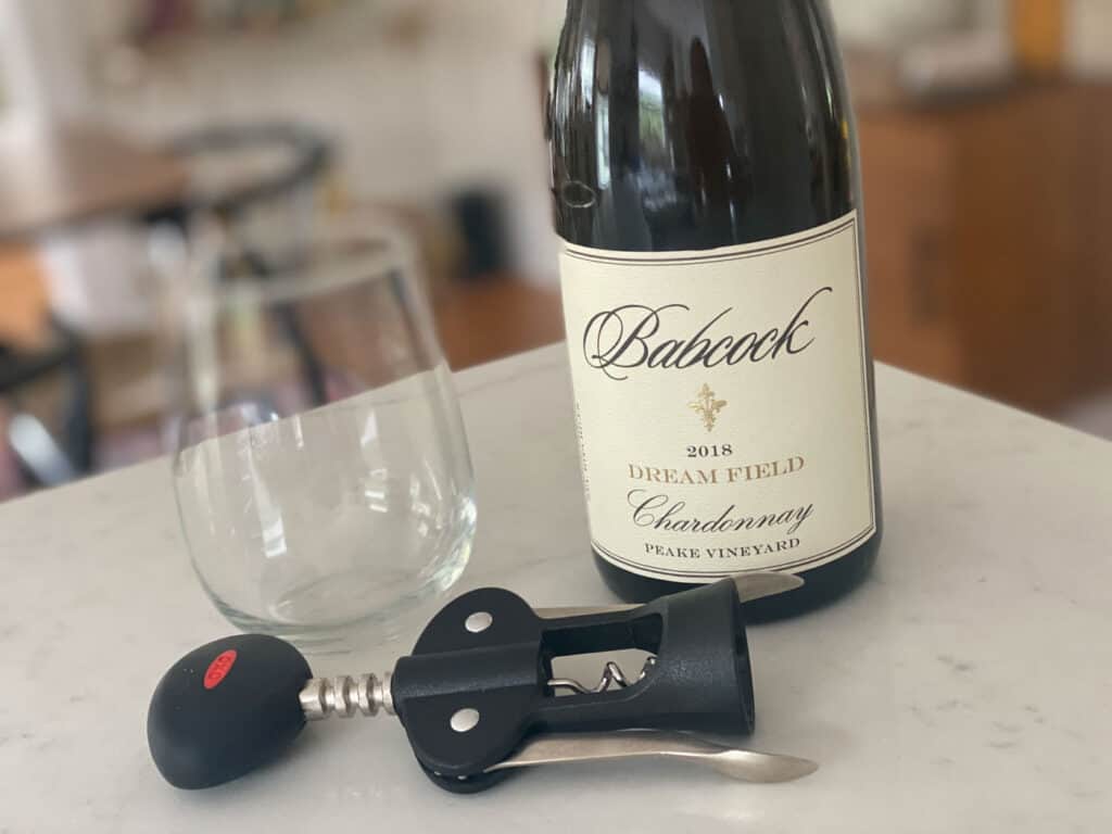 bottle of Babcock wine with a empty glass and corkscrew