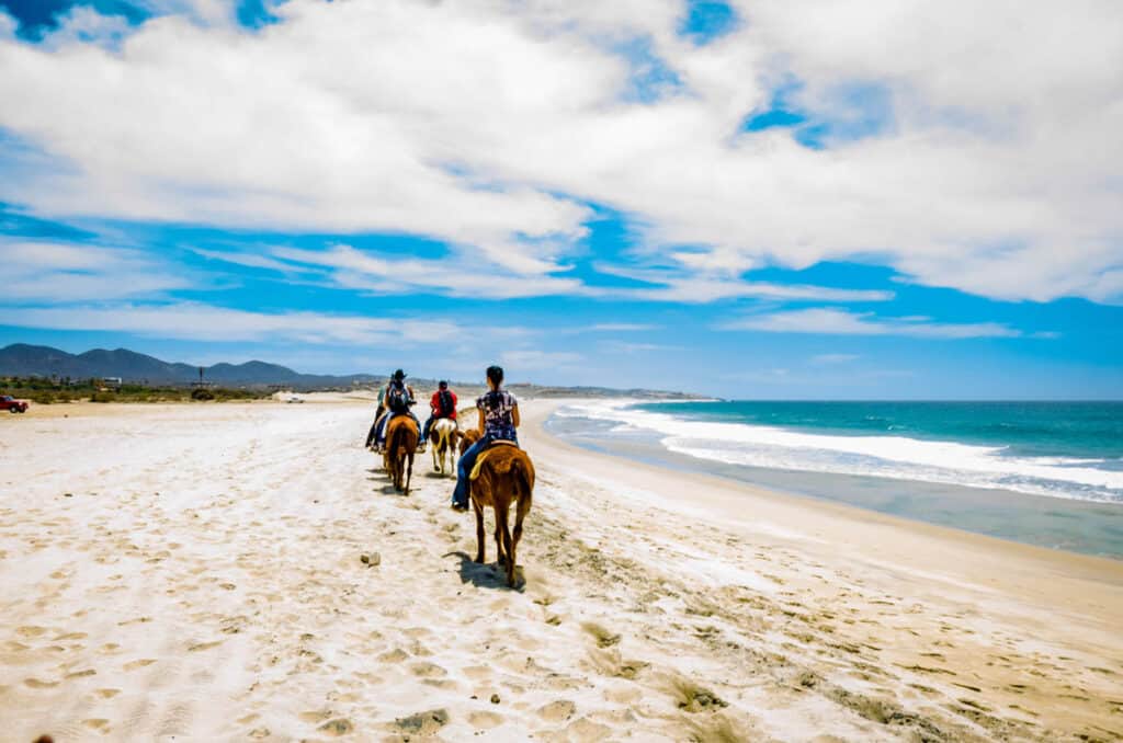 tourists ride on horseback on the beach in San Jose del cabo