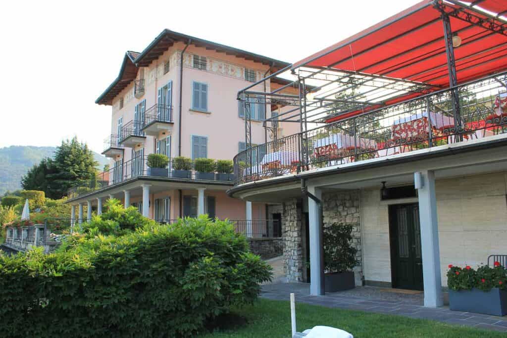 a four story orange building next to an open air terrace dining room