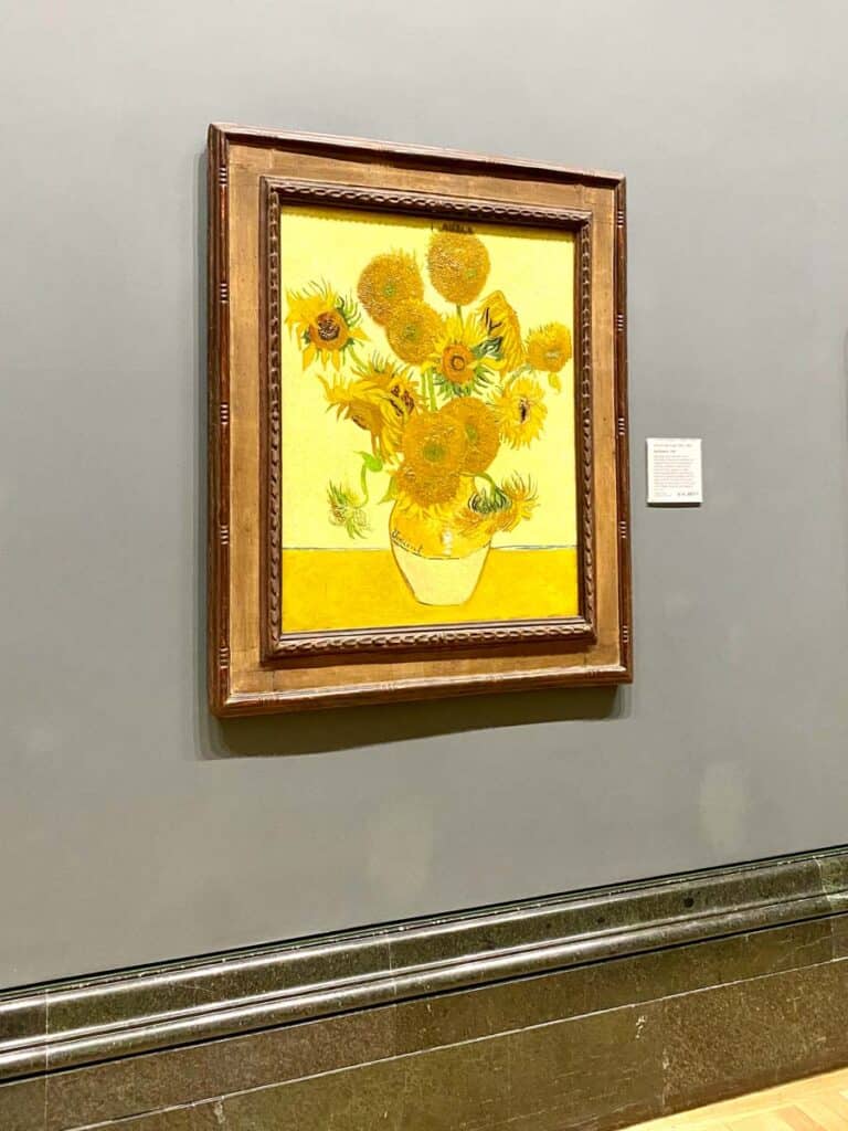 A framed oil painting of yellow sunflowers by Vincent Van Gough