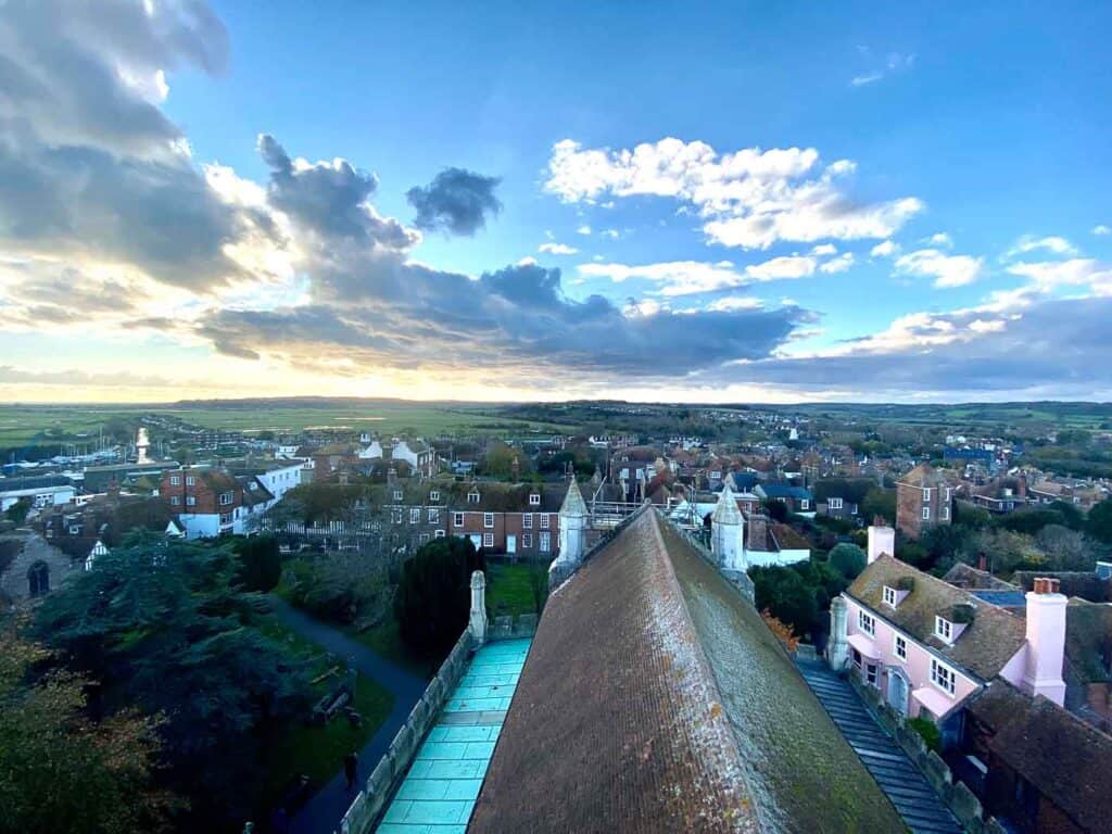 A view of mossy rooftops from above looking towards the sunset in a small English town