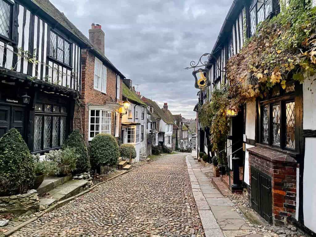 tudor style buildings line a cobblestone street in rye sussex