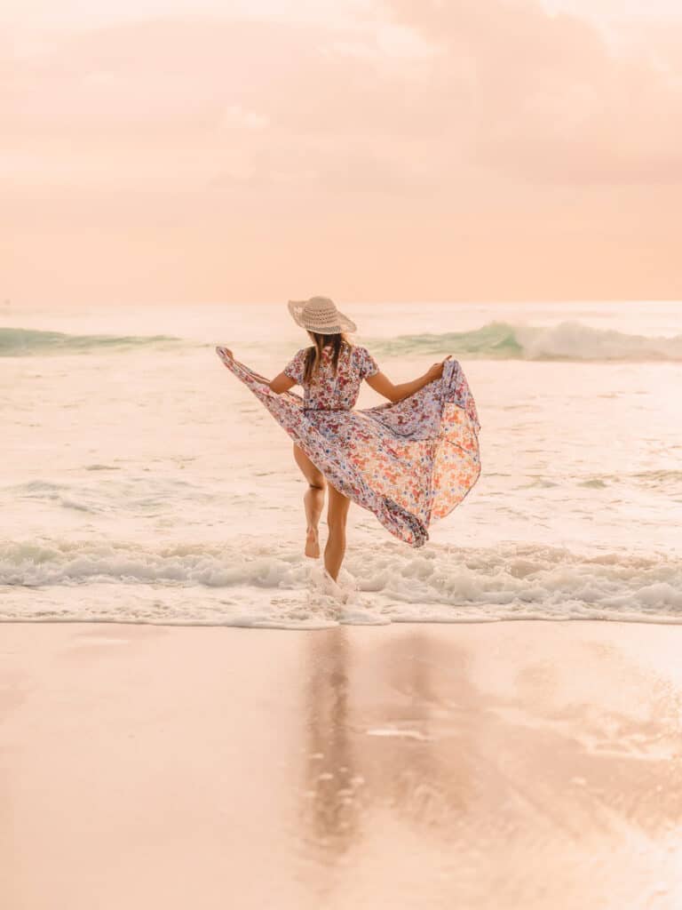 Attractive stylish woman in summer dress on beach at sunset or s