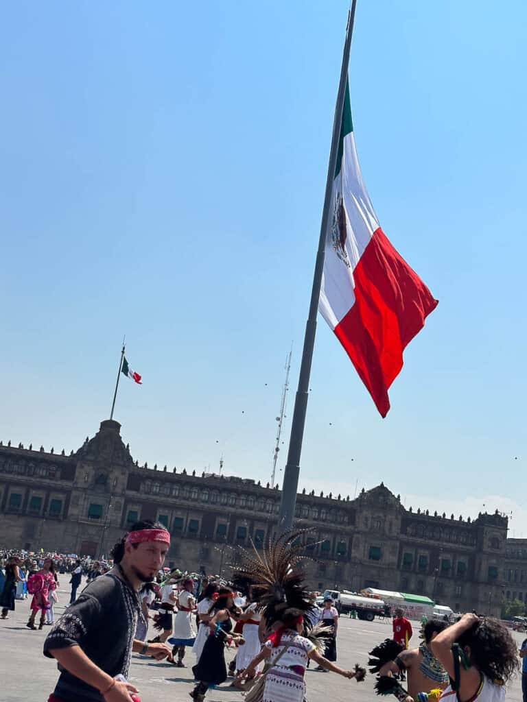 the Mexican flag waves in the breeze in front of the Palacio Nacional in Mexico City
