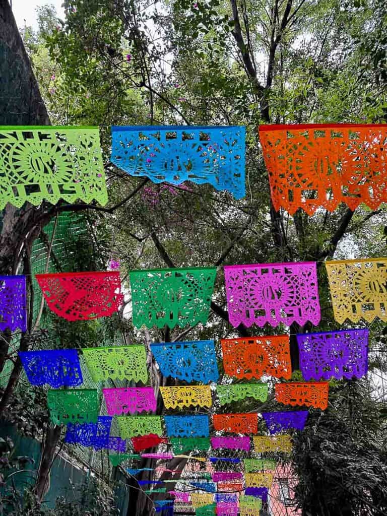 colorful flags line a street in Coyoacán, a historical neighborhood in Mexico City