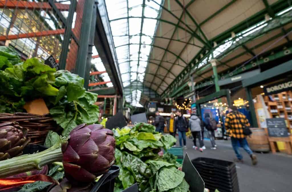 market stalls at Borough Market in London with an artichoke in the foreground.