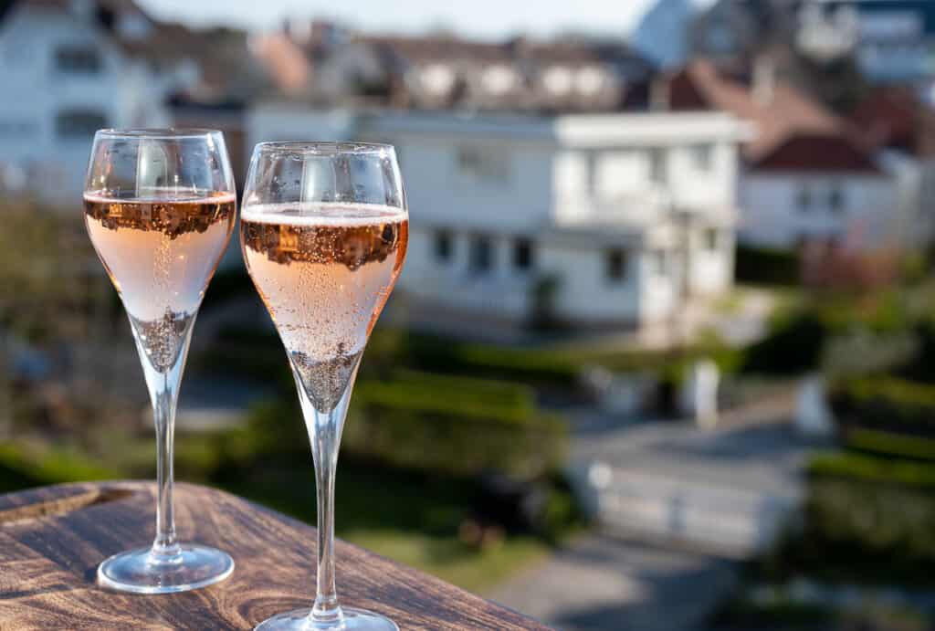 two glasses of rosé sparkling wine sit on an outdoor terrace
