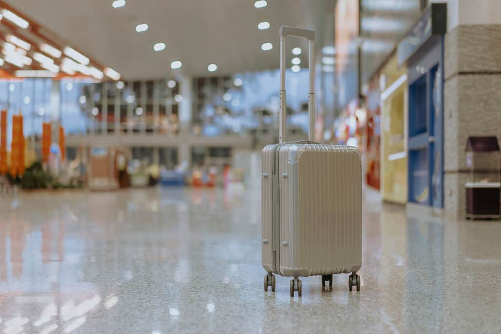 security padlock with three numbers, safety locks luggage tag label on suitcase or bag with TRAVEL INSURANCE in airport terminal station, selective focus, vintage color